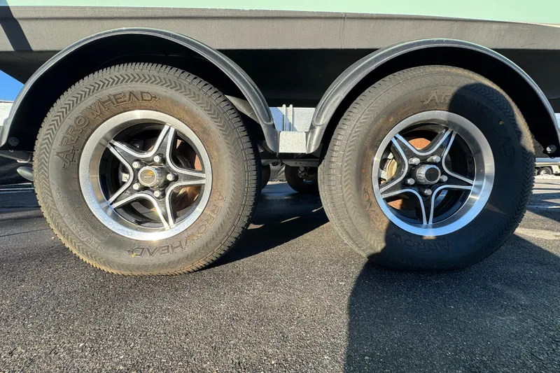 Slide: The Image of Trailer wheels of a 2021 Key West 203 DFS boat on asphalt. - 56