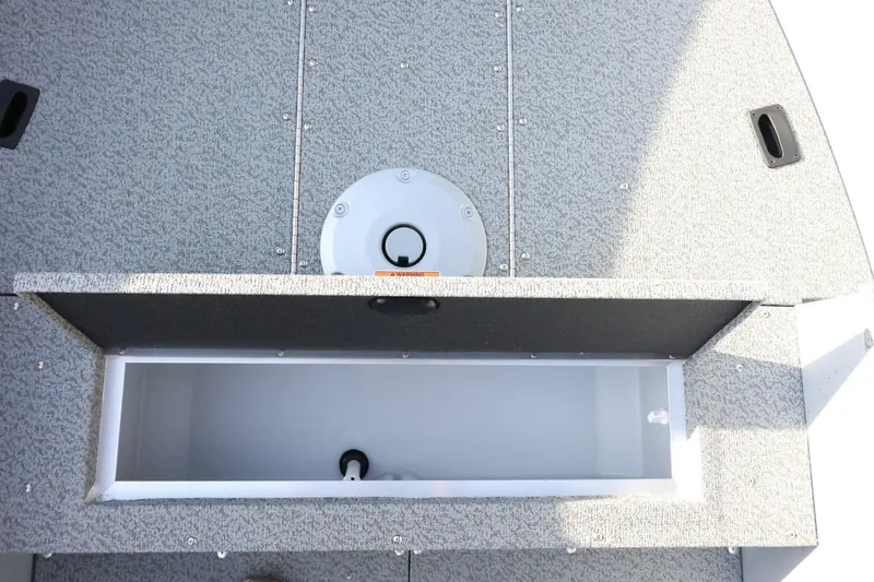 Slide: The Image of 2026 Lund 1600 Fury Tiller boat storage compartment with textured gray finish. - 14