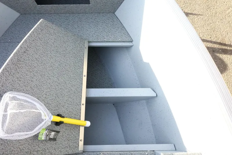 Slide: The Image of 2026 Lund 1600 Fury Tiller boat interior with fishing net on textured surface. - 15