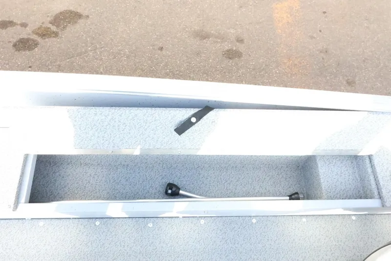 Slide: The Image of 2026 Lund 1600 Fury Tiller boat interior with storage compartment and handle. - 17