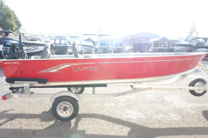 Slide: The Image of 2026 Lund 1600 Fury Tiller boat in bright red on a trailer. - 5