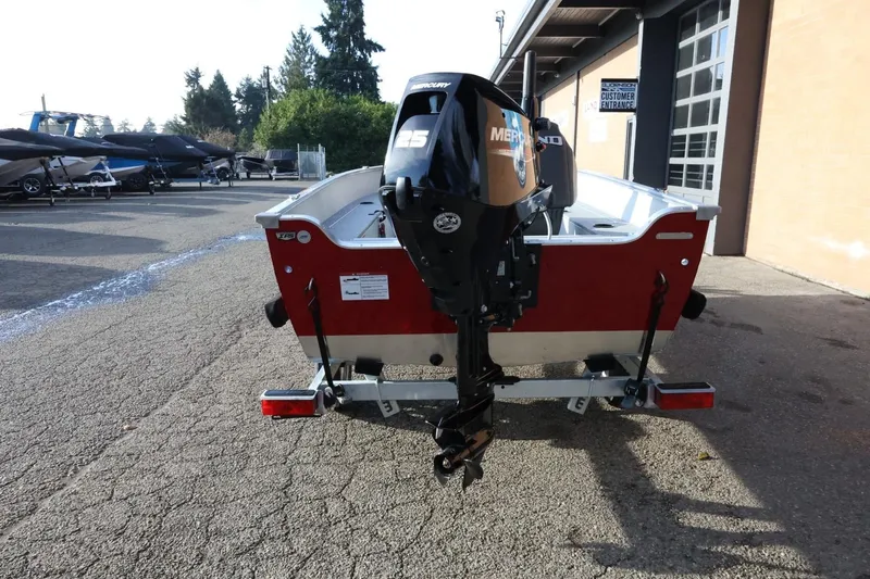 Slide: The Image of 2026 Lund 1600 Fury Tiller boat with Mercury outboard motor, parked outdoors. - 9