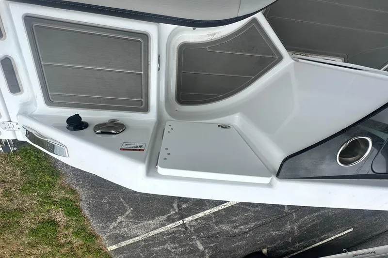 Slide: The Image of 2026 Monterey Elite 25 OB boat deck with storage compartments and cup holder. - 12