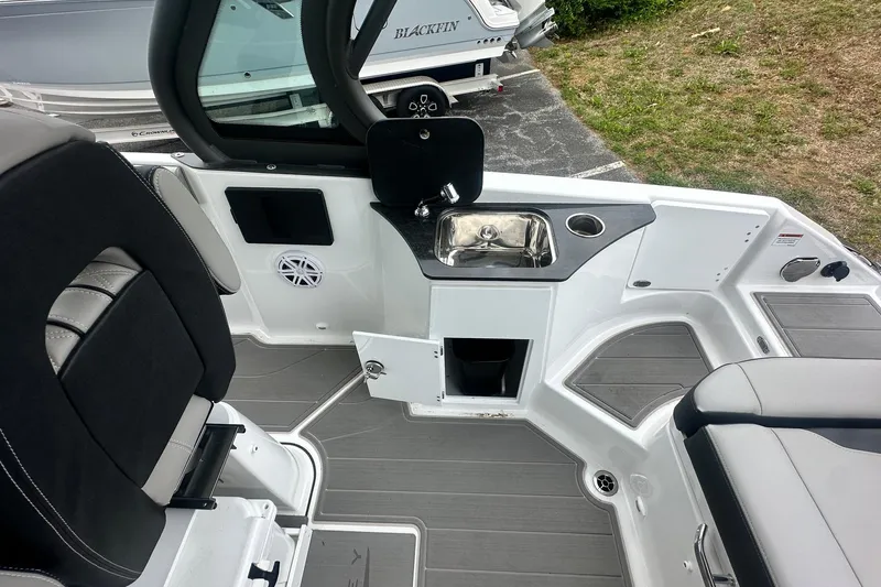 Slide: The Image of Interior view of 2026 Monterey Elite 25 OB boat featuring seating and a compact sink area. - 13