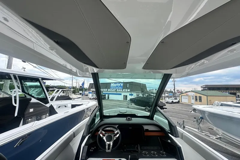 Slide: The Image of Interior view of a 2026 Monterey Elite 25 OB boat at a dealership. - 17