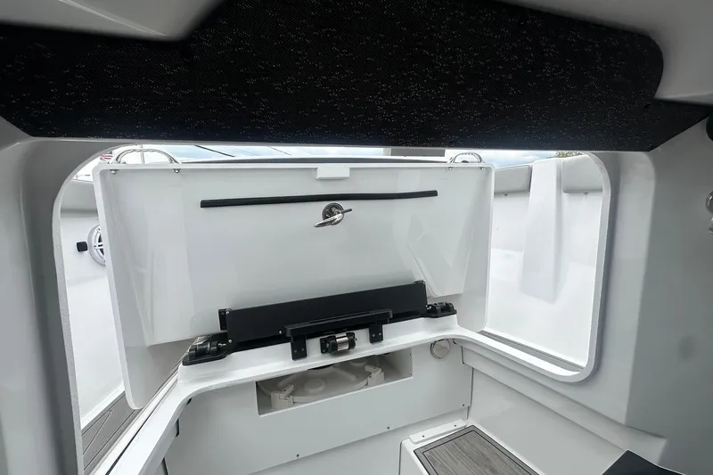 Slide: The Image of Interior view of 2026 Monterey Elite 25 OB boat, showcasing storage compartment and sleek design. - 22