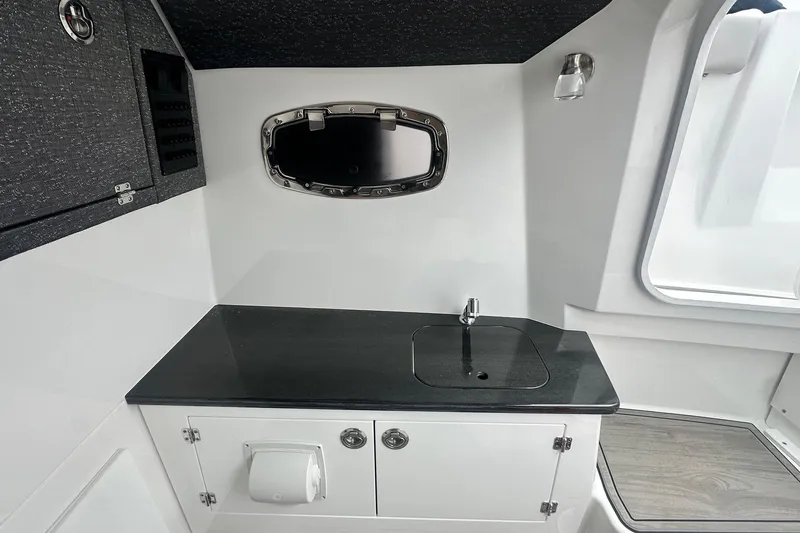 Slide: The Image of Modern kitchenette in 2026 Monterey Elite 25 OB boat with sleek black countertop. - 24