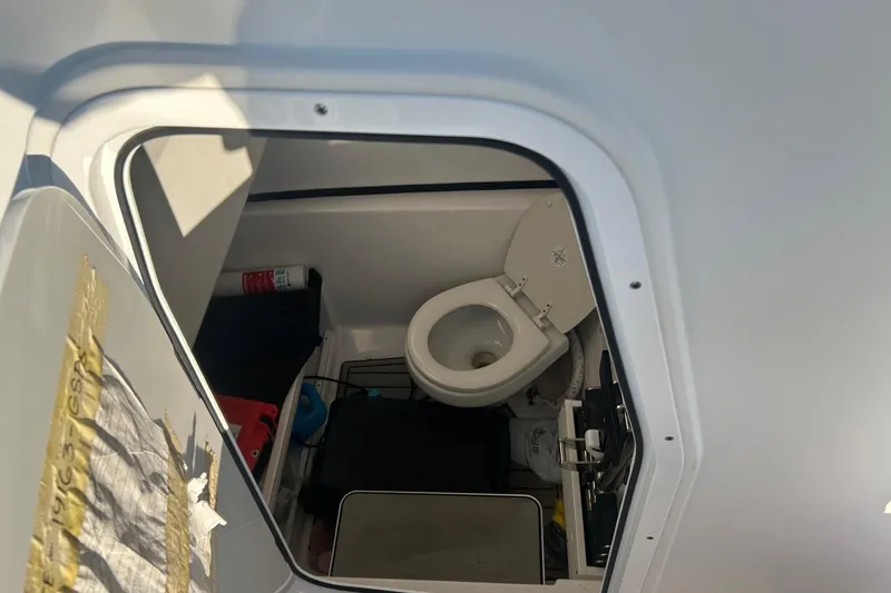 Slide: The Image of 2022 Sportsman Open 282TE Center Console boat interior with toilet and storage. - 6