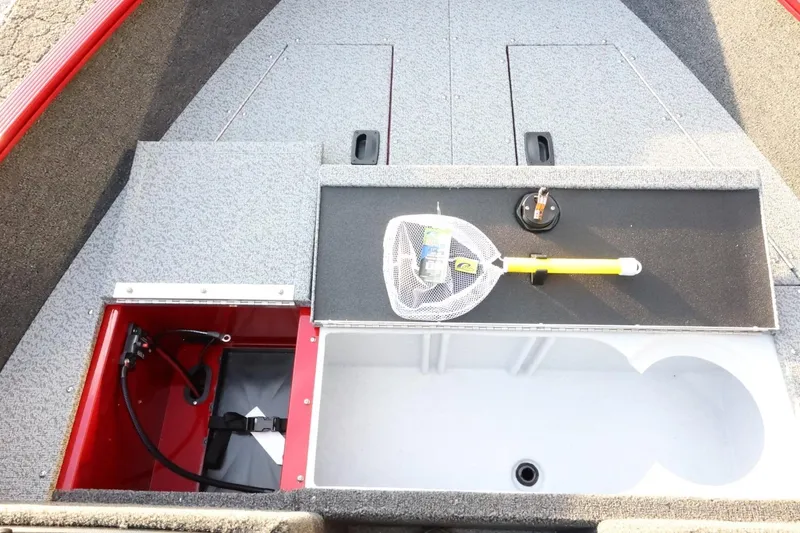 Slide: The Image of 2026 Lund 1650 Angler Sport boat interior with storage compartments and fishing gear. - 13