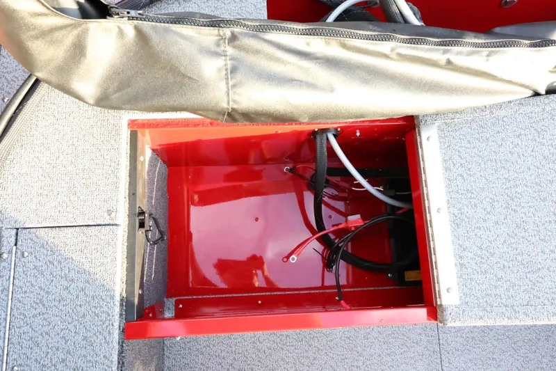Slide: The Image of 2026 Lund 1650 Angler Sport boat storage compartment with wiring and red interior. - 18