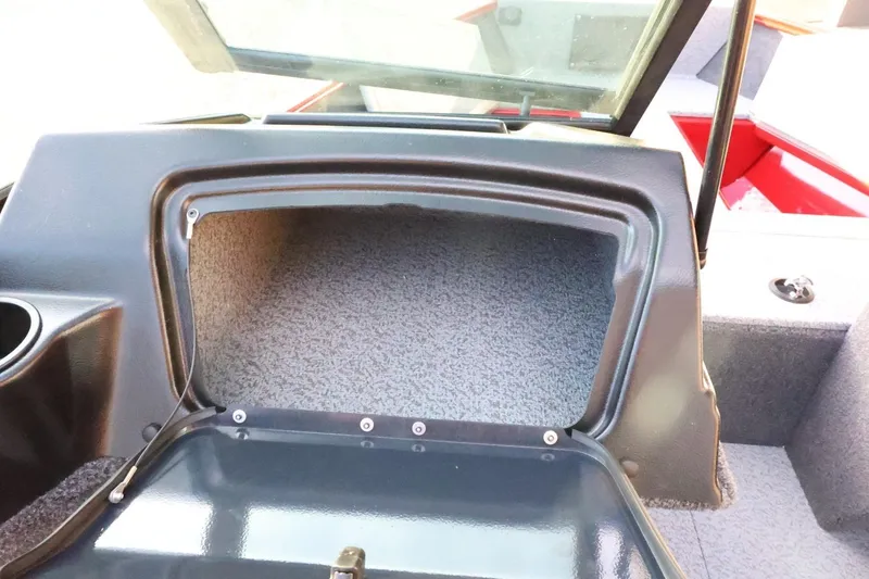 Slide: The Image of 2026 Lund 1650 Angler Sport boat dashboard storage compartment open. - 23