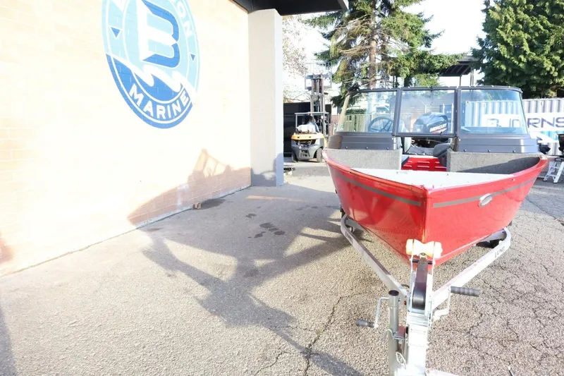 Slide: The Image of 2026 Lund 1650 Angler Sport boat on trailer outside marine shop. - 4