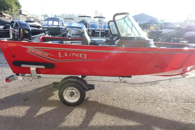 Slide: The Image of 2026 Lund 1650 Angler Sport boat in vibrant red on a trailer. - 6