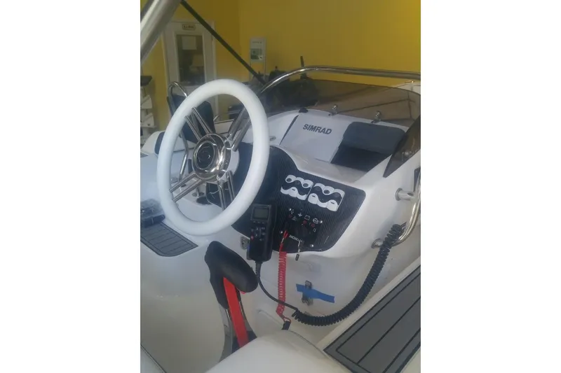 The Image of 2018 Walker Bay Generation 525 DLX boat dashboard with steering wheel and control panel. - 0
