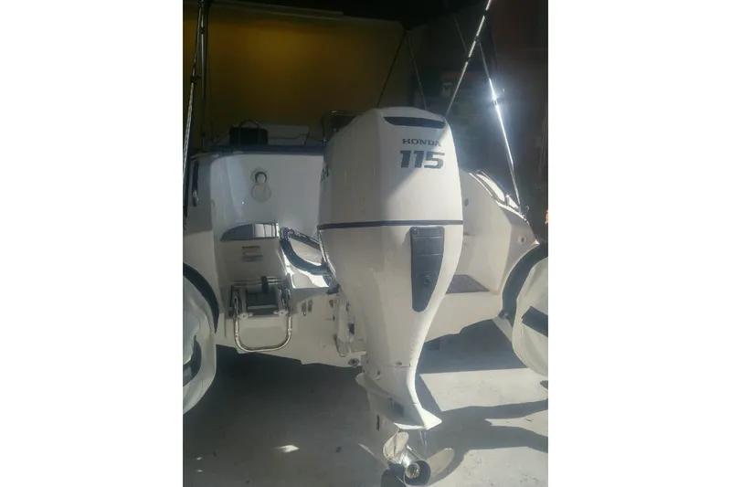 Slide: The Image of 2018 Walker Bay Generation 525 DLX with Honda 115 outboard motor in a garage. - 3