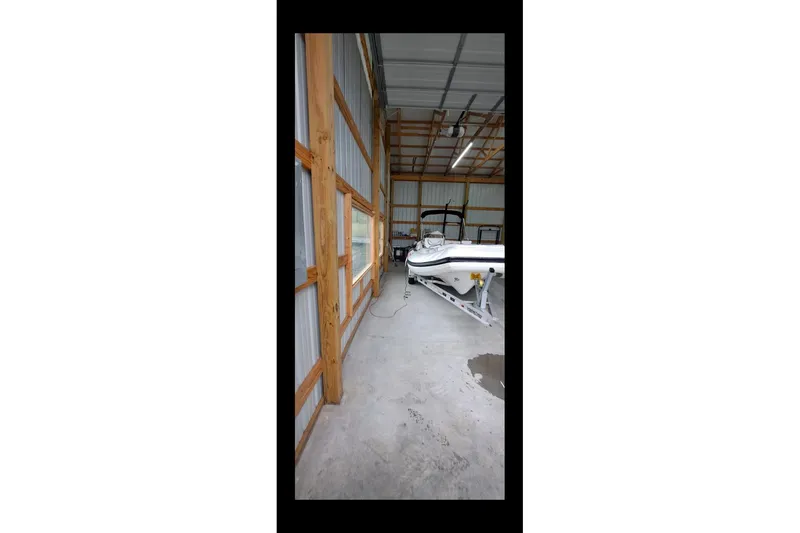 Slide: The Image of 2018 Walker Bay Generation 525 DLX boat stored in a wooden garage. - 4