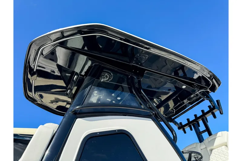 Slide: The Image of 2026 Tidewater 3100 Carolina Bay boat with sleek black T-top against clear blue sky. - 14