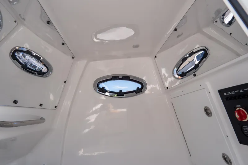 Slide: The Image of Interior view of 2026 Tidewater 3100 Carolina Bay boat cabin with portholes. - 18