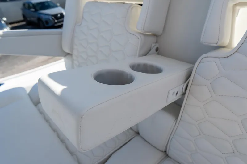 Slide: The Image of 2026 Tidewater 3100 Carolina Bay boat interior with white leather seats and cup holders. - 23