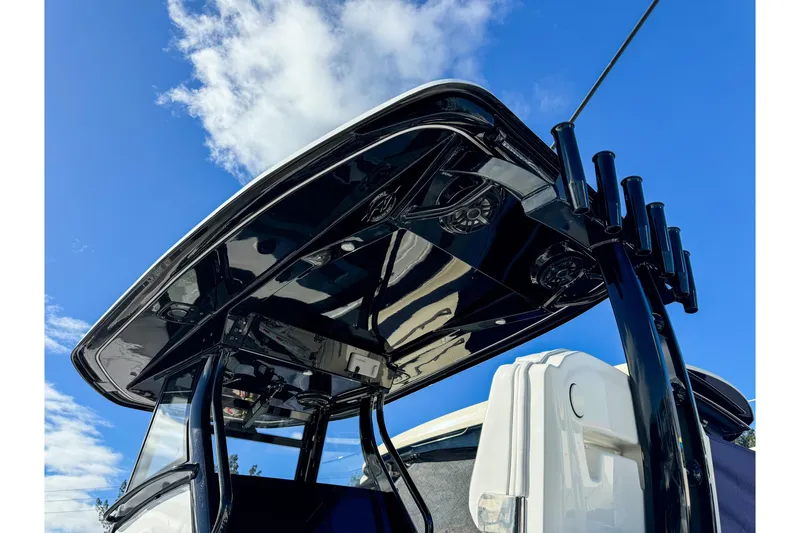 Slide: The Image of 2026 Tidewater 3100 Carolina Bay boat with sleek black T-top against blue sky. - 24