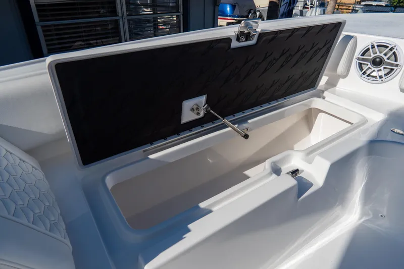 Slide: The Image of 2026 Tidewater 3100 Carolina Bay boat storage compartment with open lid and speaker. - 8