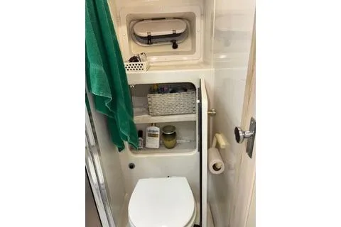 Slide: The Image of 1997 Bayliner 3788 Command Bridge Motoryacht bathroom with toilet, shelves, and window. - 26