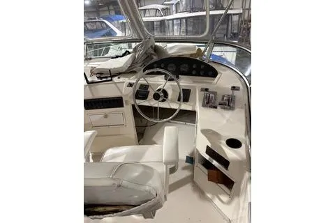 Slide: The Image of 1997 Bayliner 3788 Command Bridge Motoryacht helm with steering wheel and controls. - 31