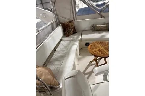 Slide: The Image of 1997 Bayliner 3788 Command Bridge Motoryacht interior with white seating and wooden table. - 34
