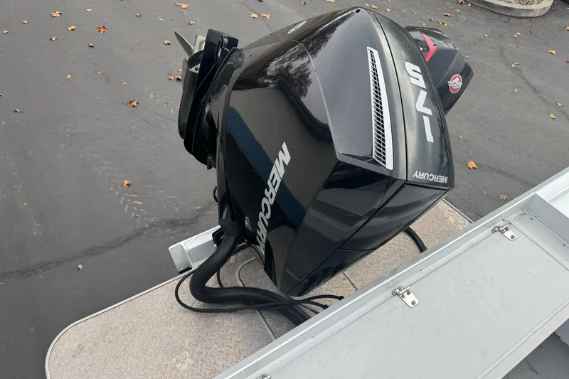 Slide: The Image of Outboard motor on a 2021 KingFisher 2025 Escape HHT boat, parked on pavement. - 12