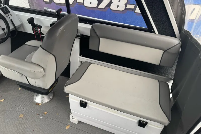 Slide: The Image of Interior of 2021 KingFisher 2025 Escape HHT boat with gray seating and controls. - 20
