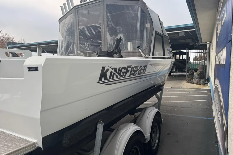 Slide: The Image of KingFisher 2025 Escape HHT boat on trailer, side view, parked outdoors. - 9