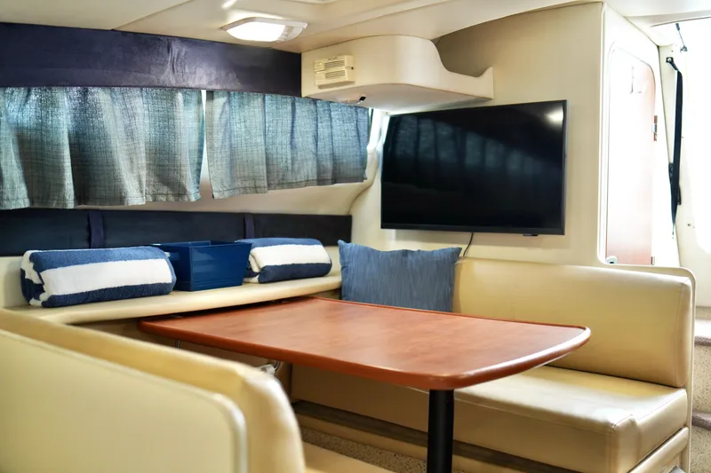 Slide: The Image of Interior of 2006 Bayliner 285 boat with seating, table, and TV. - 22