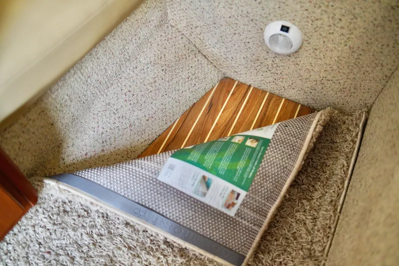 Slide: The Image of Interior of 2006 Bayliner 285 boat showing carpet and wooden flooring detail. - 23