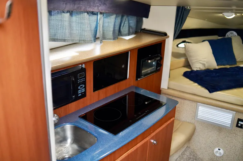 Slide: The Image of 2006 Bayliner 285 interior with kitchenette and cozy sleeping area. - 25