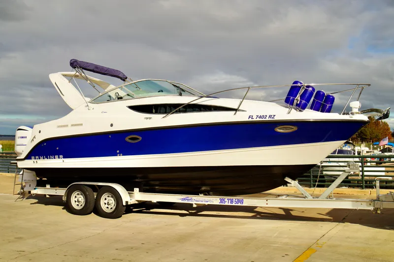 Slide: The Image of 2006 Bayliner 285 boat on trailer, blue and white design, docked at marina. - 3