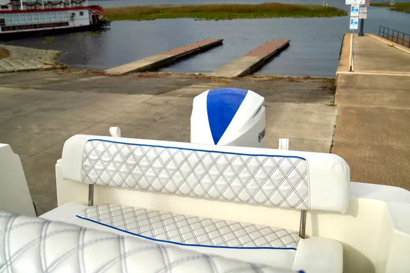 Slide: The Image of 2006 Bayliner 285 boat interior with diamond-stitched seating at a boat launch. - 40