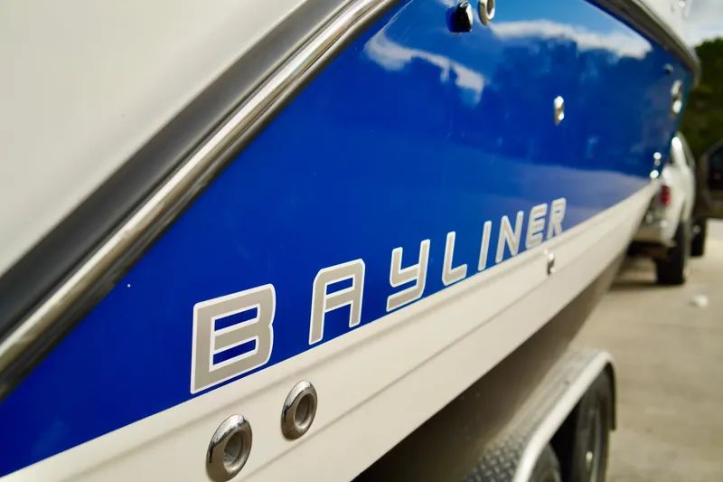 Slide: The Image of 2006 Bayliner 285 boat with blue and white exterior on a trailer. - 48