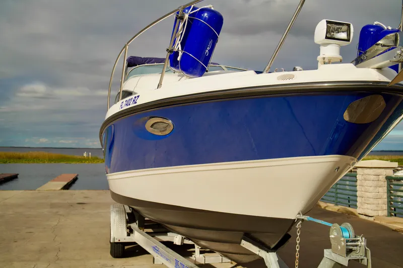 Slide: The Image of 2006 Bayliner 285 boat on trailer at dockside, blue and white exterior. - 5