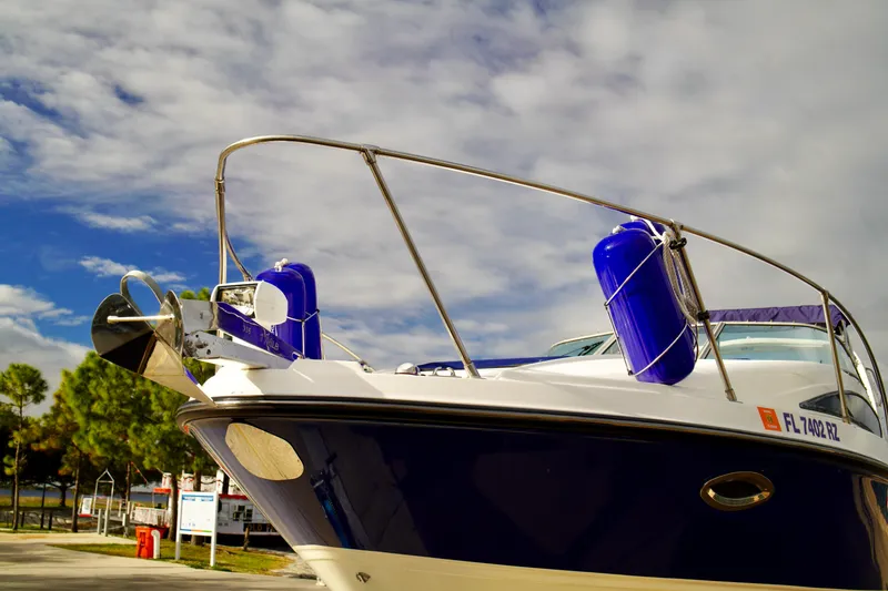 Slide: The Image of 2006 Bayliner 285 boat with blue fenders, docked under a cloudy sky. - 6