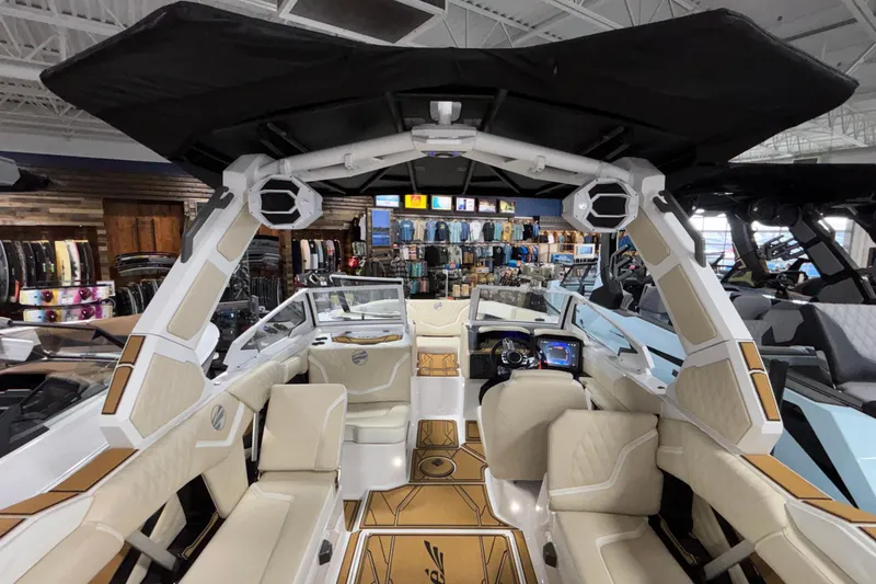 Slide: The Image of 2026 Tigé 22RZX boat interior with beige seating and modern dashboard in showroom. - 13