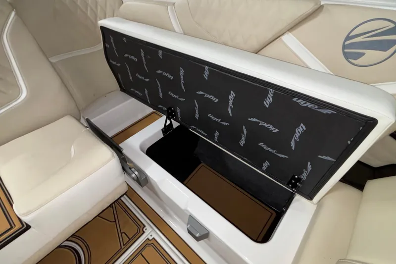 Slide: The Image of 2026 Tigé 22RZX boat interior with open storage compartment and beige seating. - 43