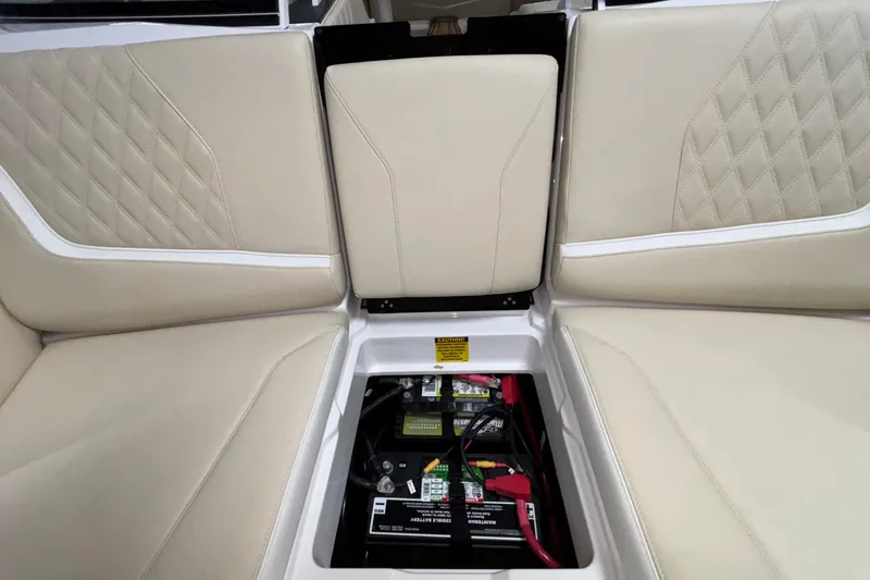 Slide: The Image of 2026 Tigé 22RZX boat interior with battery compartment, beige seating, and diamond stitching. - 48