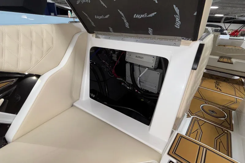 Slide: The Image of 2026 Tigé 22RZX boat interior with open storage compartment and audio equipment. - 50
