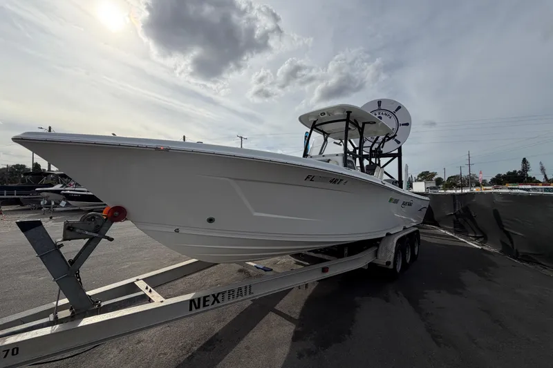 Slide: The Image of 2018 Blue Wave 2800 Pure Hybrid boat on trailer under sunny sky. - 10