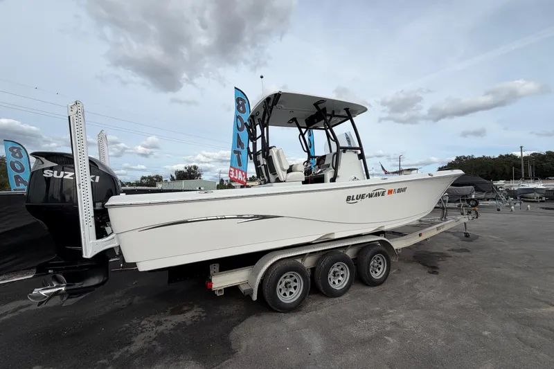 Slide: The Image of 2018 Blue Wave 2800 Pure Hybrid boat on trailer with Suzuki outboard motor. - 2
