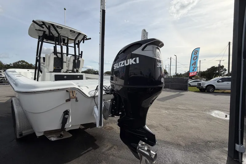Slide: The Image of 2018 Blue Wave 2800 Pure Hybrid boat with Suzuki outboard motor, parked outdoors. - 7