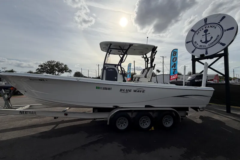Slide: The Image of 2018 Blue Wave 2800 Pure Hybrid boat on trailer under sunny sky. - 9
