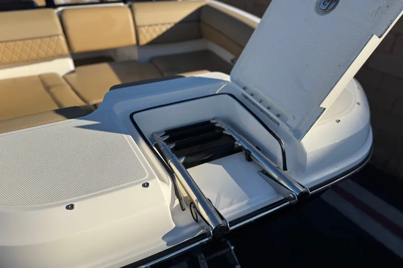 Slide: The Image of 2023 Bayliner DX 2050 boat with open storage compartment and seating area. - 10