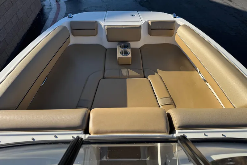 Slide: The Image of 2023 Bayliner DX 2050 boat interior with tan seating and cup holders. - 12