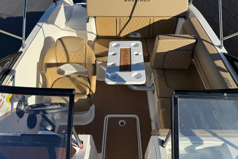 Slide: The Image of 2023 Bayliner DX 2050 boat interior with tan seating and table. - 16
